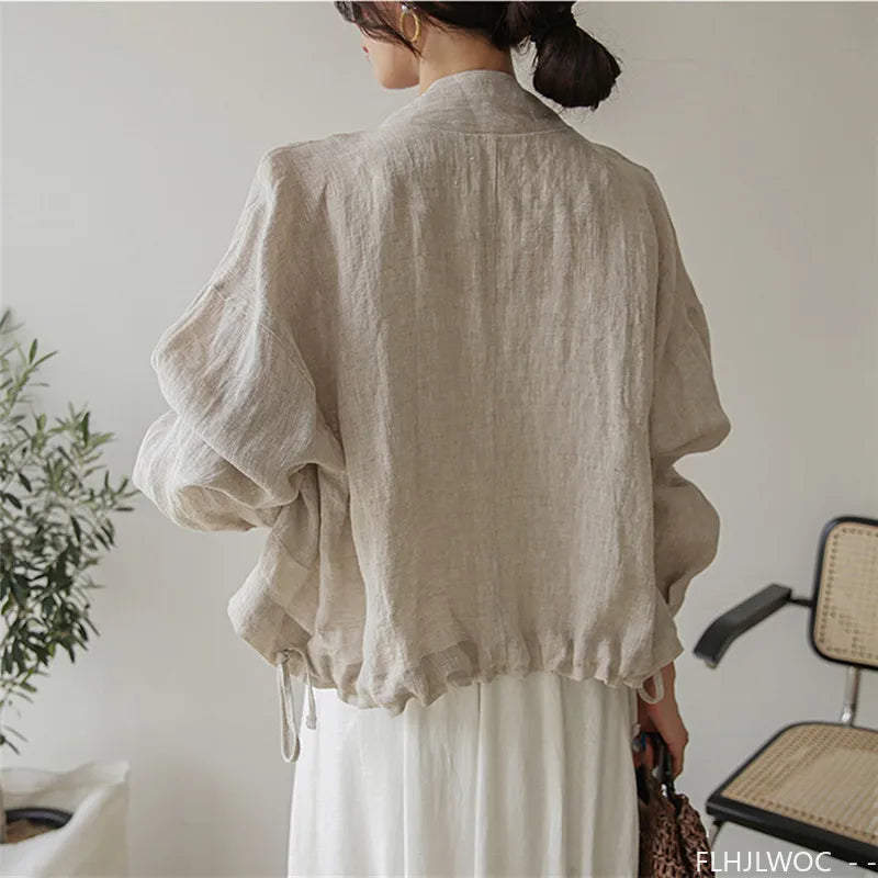 Person wearing a beige linen shirt in a minimal indoor setting