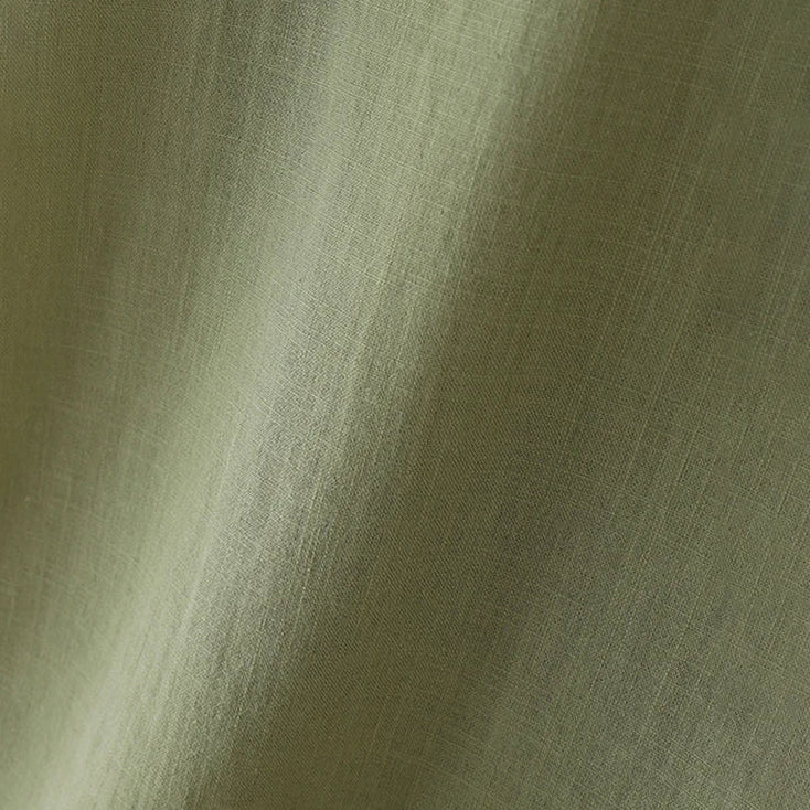A close-up of a textured fabric in a muted sage green color, showing the weave and soft folds.