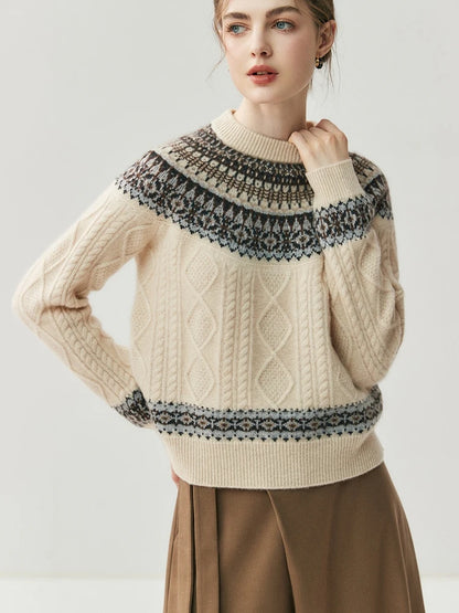 Woman wearing a beige sweater with black patterned neckline on a light gray background