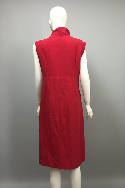 Red sleeveless dress on a mannequin against a blue wall