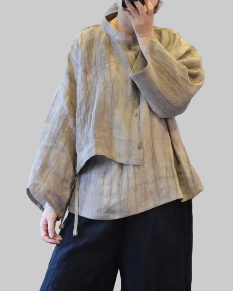 Person wearing a beige textured jacket and dark pants indoors.