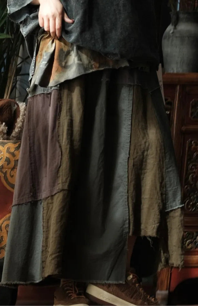 Person wearing a long, layered garment with a decorative background