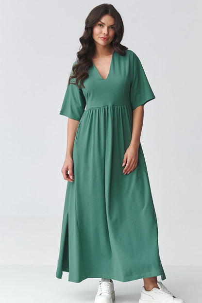 Woman wearing a cotton green dress, v-neck on a white background