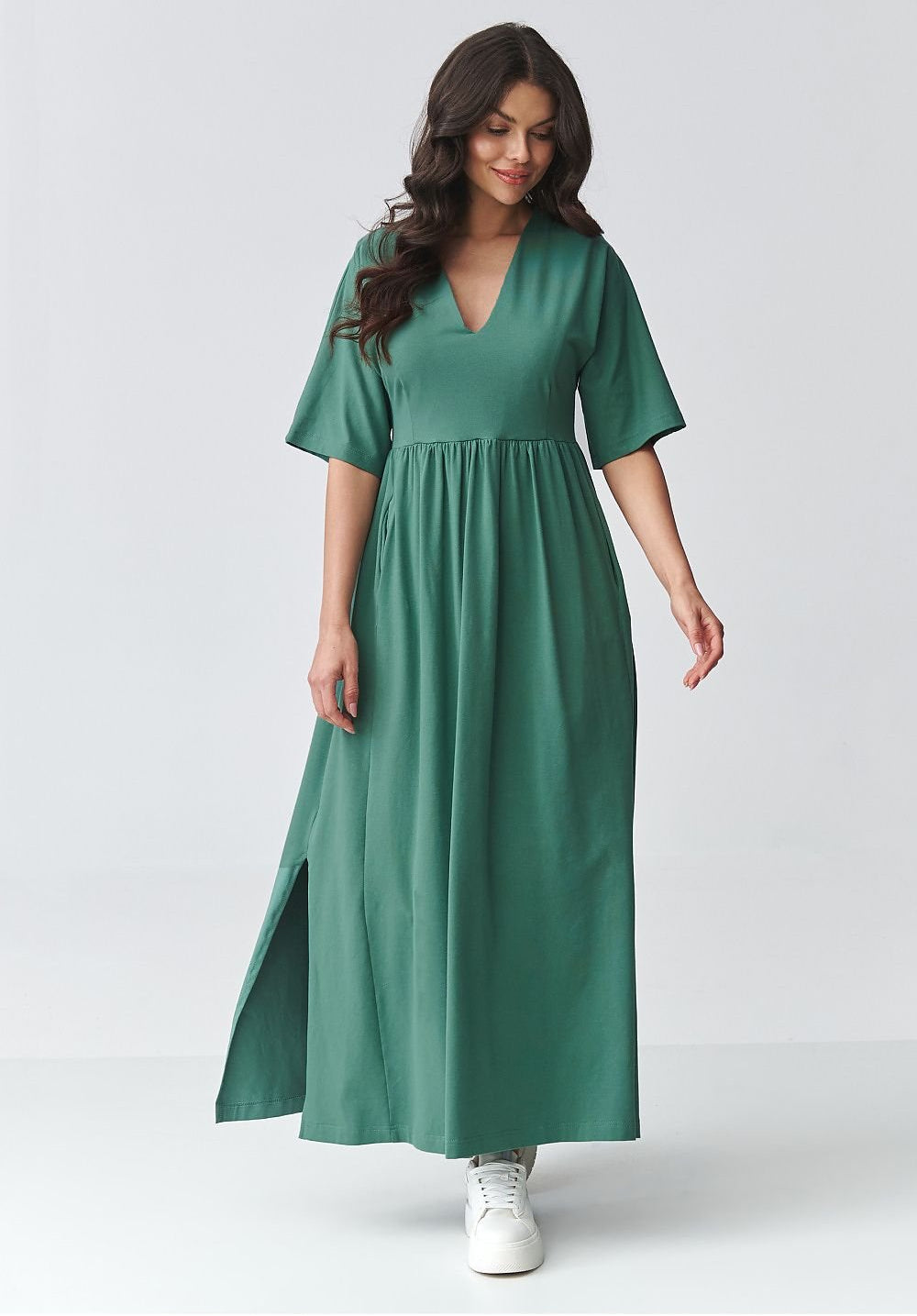 Woman wearing a cotton green dress on a white background