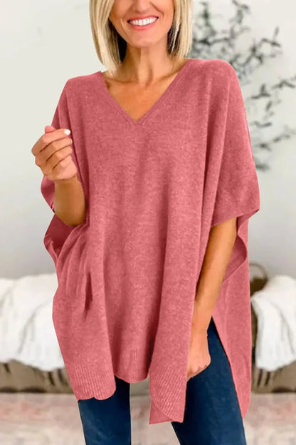 Woman wearing a pink oversized sweater with a blurred indoor background