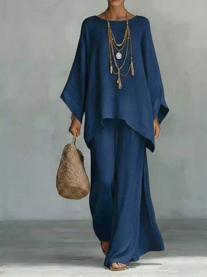 Person wearing a blue outfit holding a woven bag against a gray background