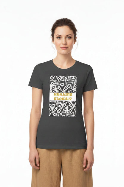 A woman modeling a dark charcoal gray t-shirt with a graphic on the front. The graphic features a white rectangular center with the words &