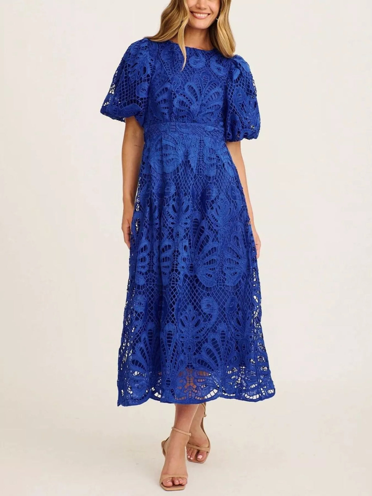 Woman wearing a blue lace dress on a white background