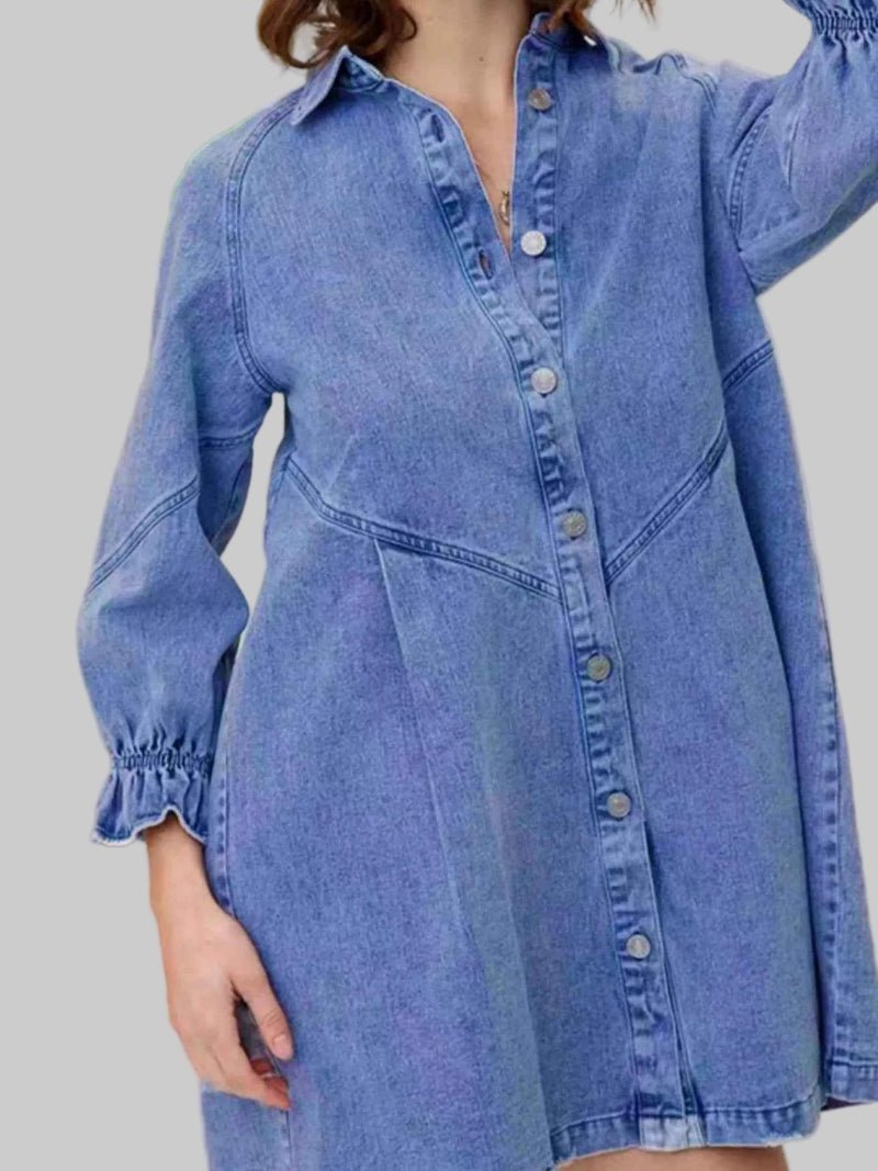Blue denim dress worn by a person on a gray background