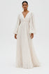 A model wearing a floor-length cream lace gown with long balloon sleeves, a deep V-neckline, and a gathered bodice, photographed against a seamless white studio background.