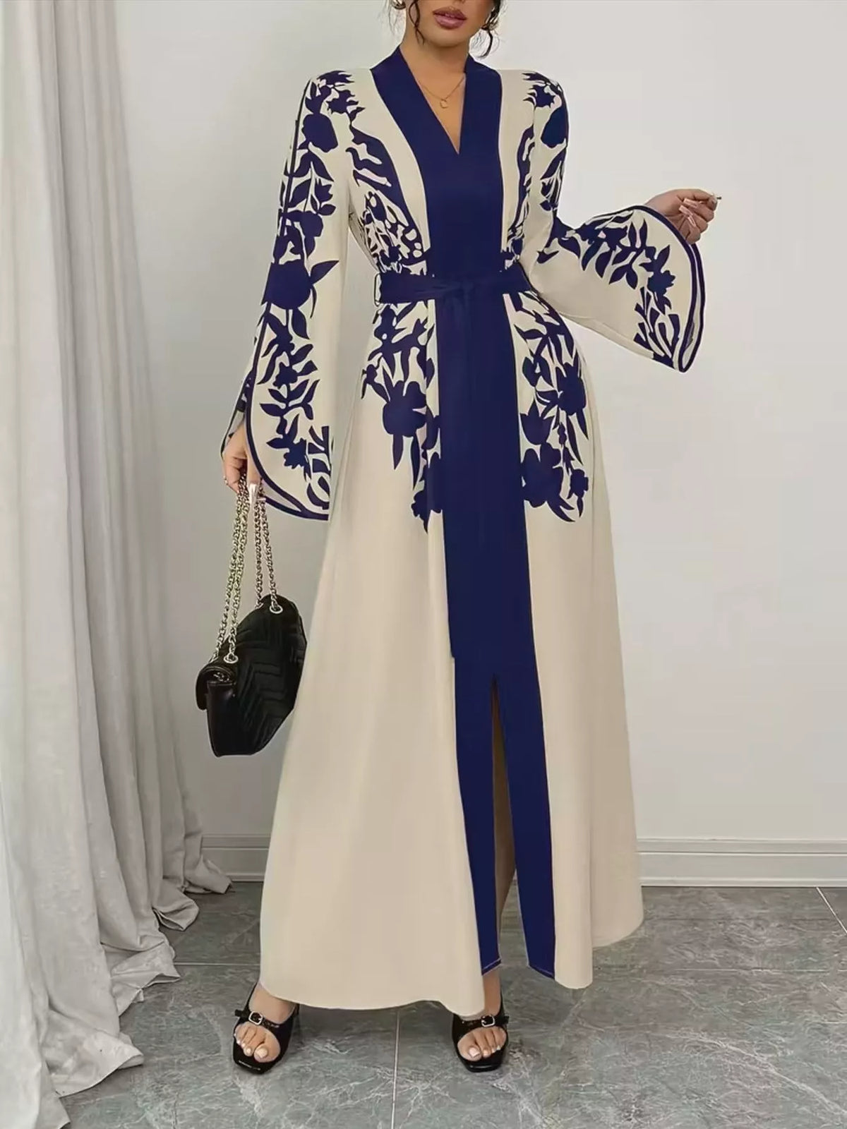 Woman wearing a long, floral embroidered dress with a blue and white color scheme.