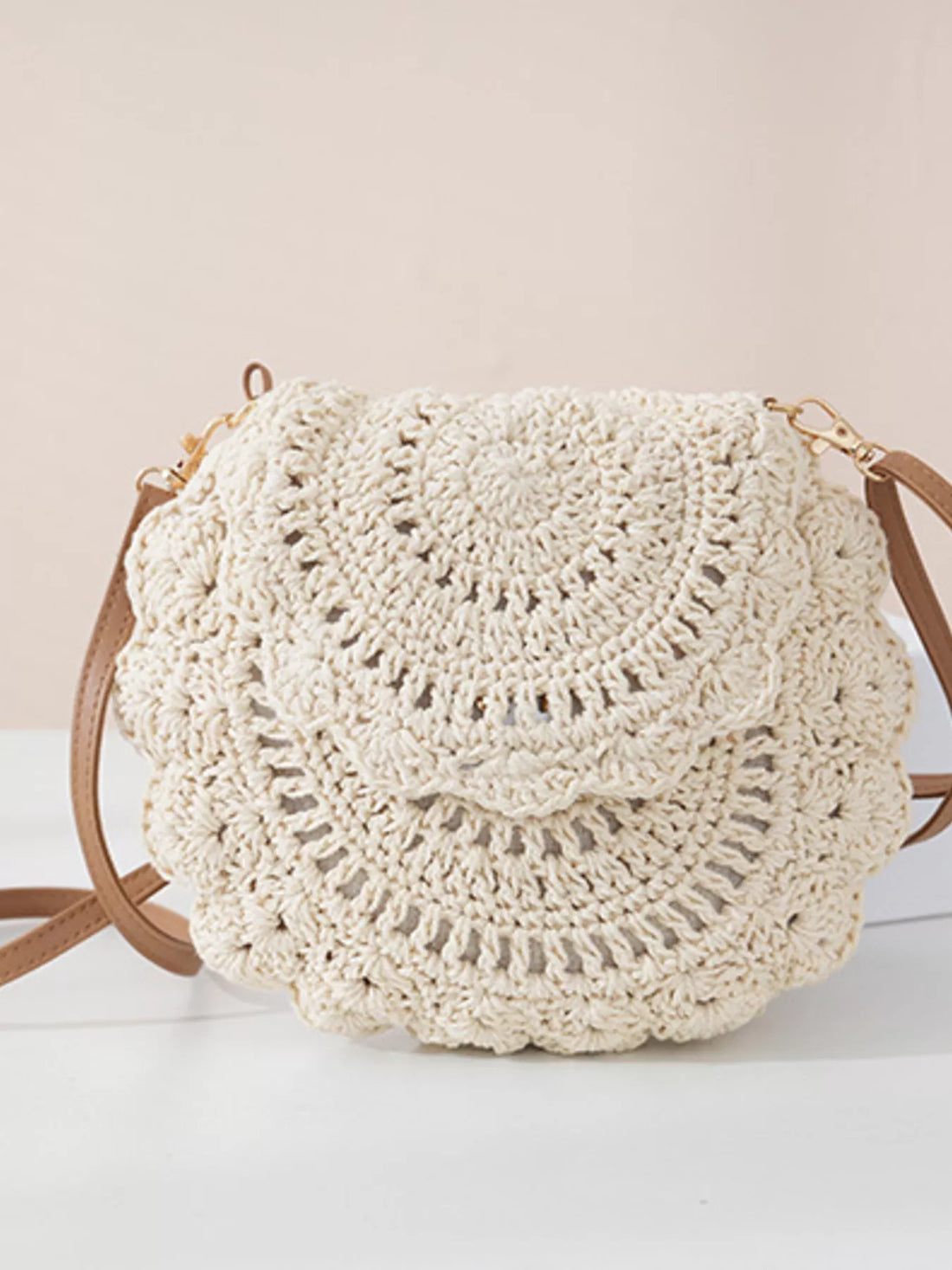 Crocheted handbag with brown straps on a light background