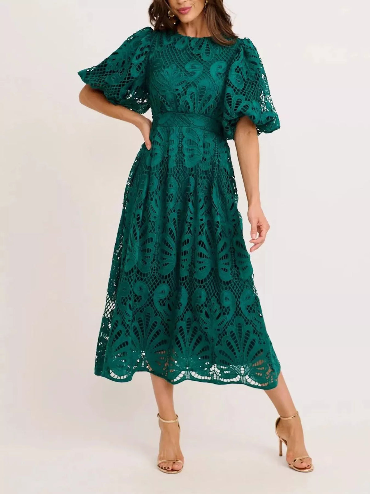 Green lace dress worn by a model on a white background