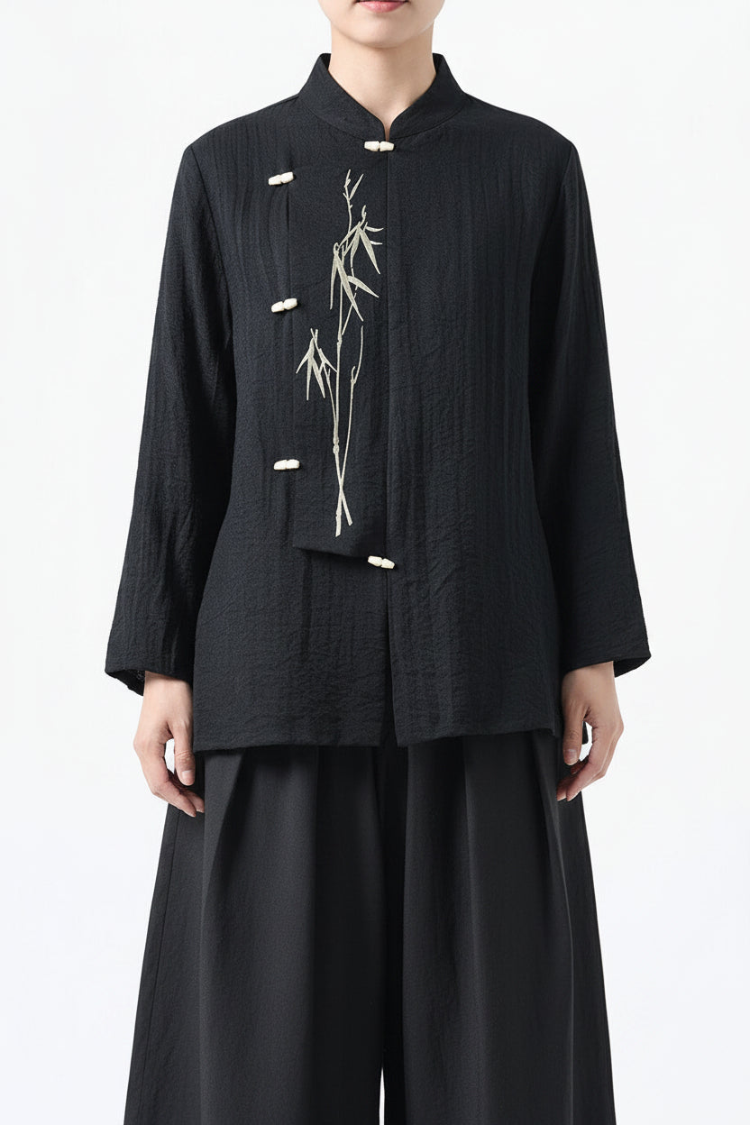 Black traditional jacket with bamboo embroidery on a white background