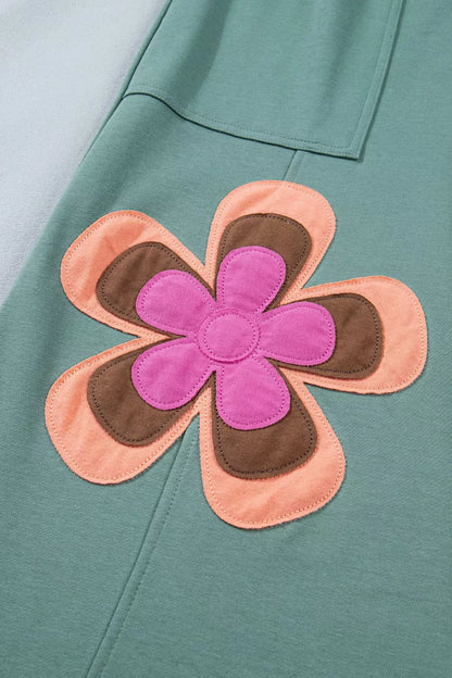 Floral patch with pink center and brown petals on a teal background