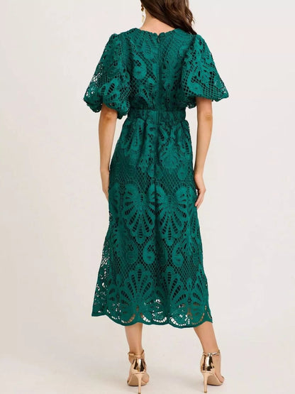 Green lace dress worn by a person on a white background