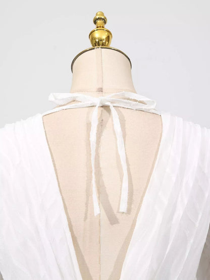 White sheer top on a mannequin with a gold top against a white background