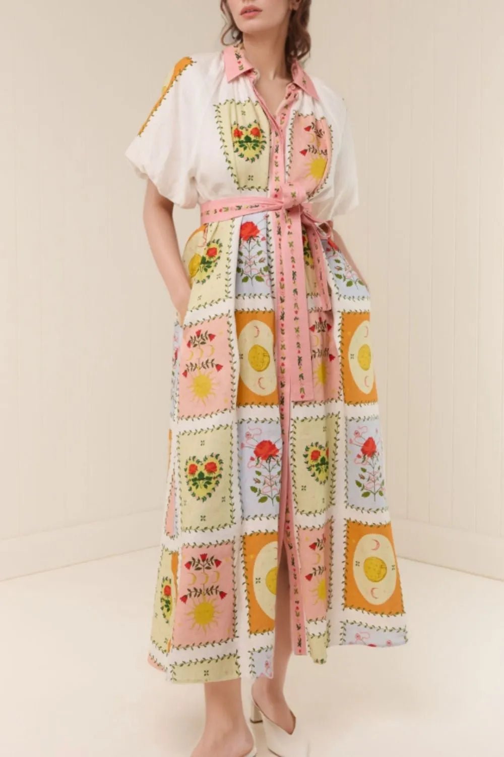 Woman wearing a colorful patchwork dress with a white background