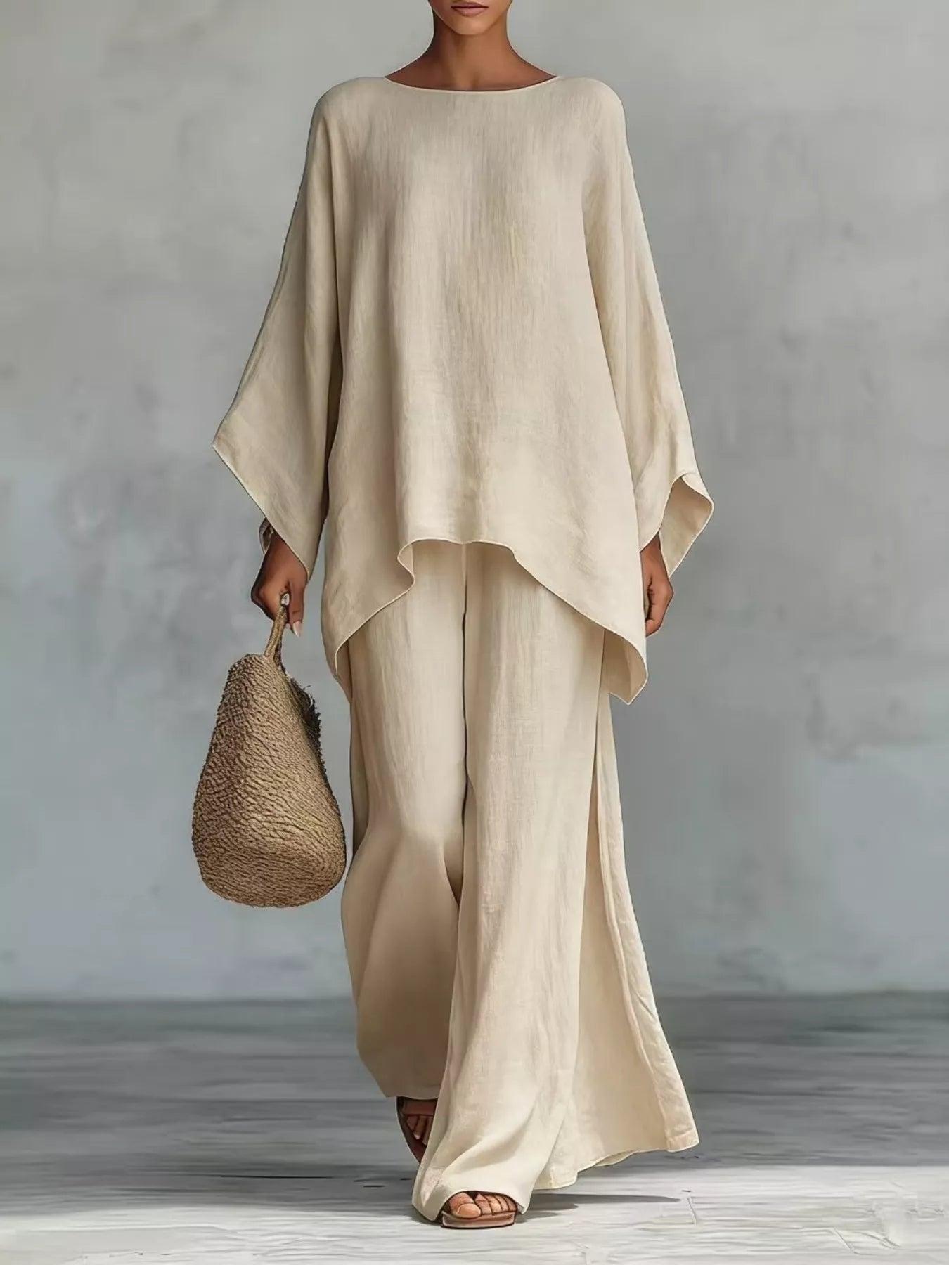 Person wearing a beige outfit holding a woven bag against a gray background
