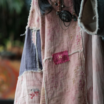 Person wearing a patchwork quilt jacket with a pink pocket and floral patterns.
