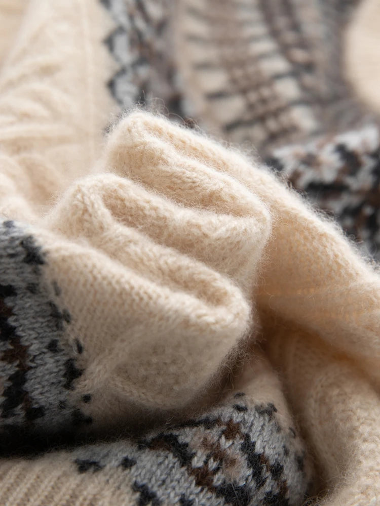 Close-up of a soft knit sweater or scarf in cream beige with a dark gray and brown Fair Isle patterned section.