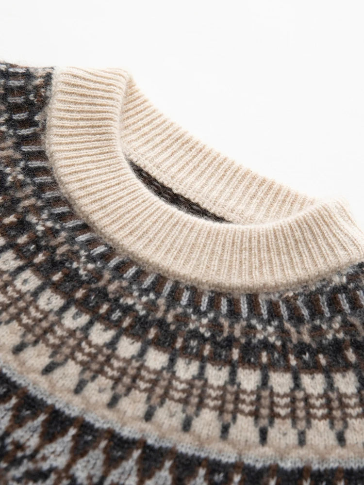 Close-up of a knit sweater showing a cream ribbed crew neck and a Fair Isle patterned yoke in cream, brown, and dark gray.