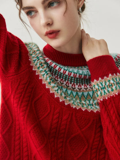 A close-up of a woman wearing a red cable-knit sweater with a multicolor Fair Isle yoke pattern in green, white, and red.