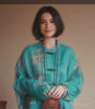 Women is wearing floral print full sleeve band collar bouse.
