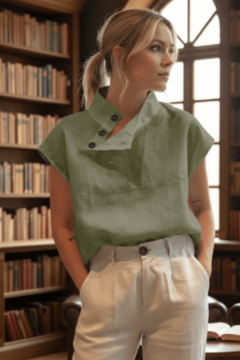 Woman wearing a green top and white pants in a library setting