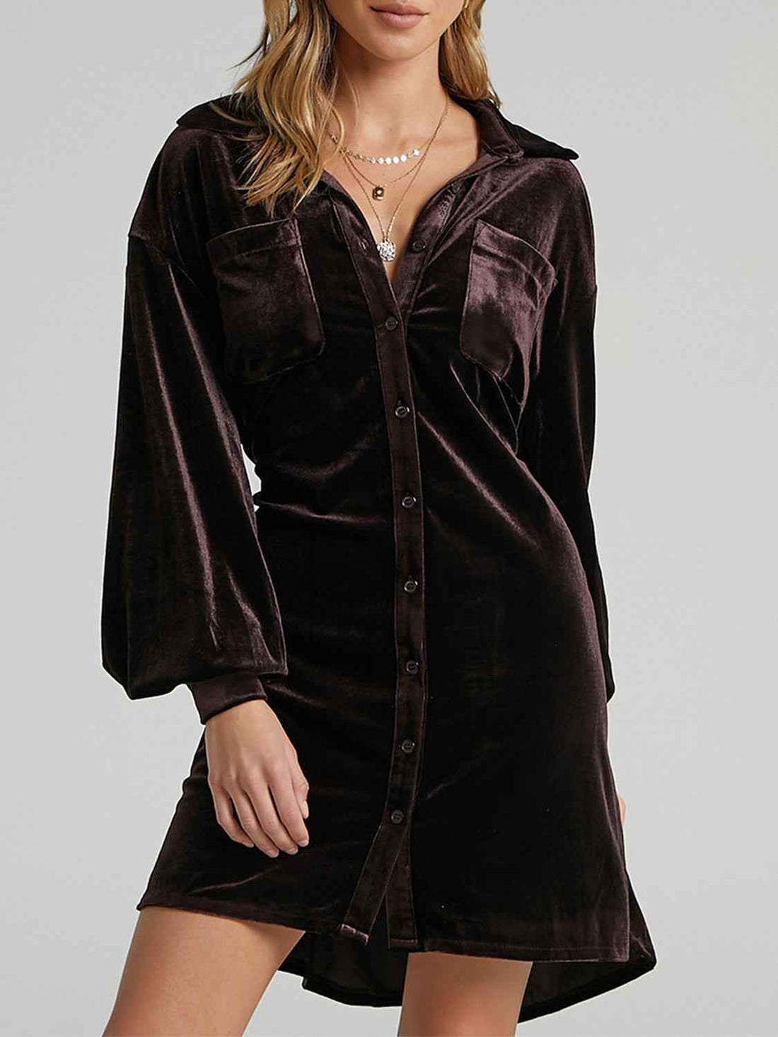 Brown velvet dress worn by a model on a gray background