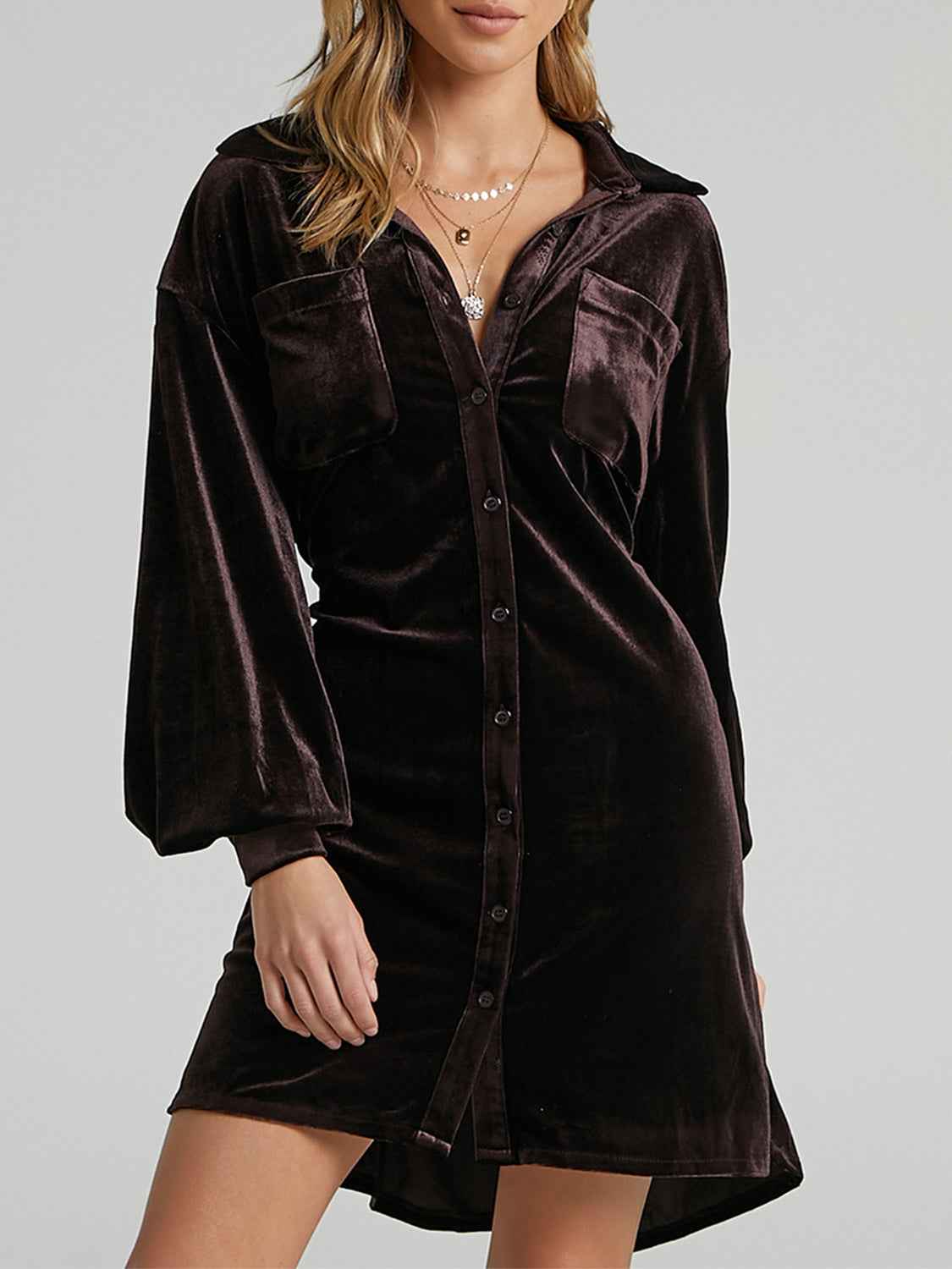 Brown velvet dress worn by a model on a gray background