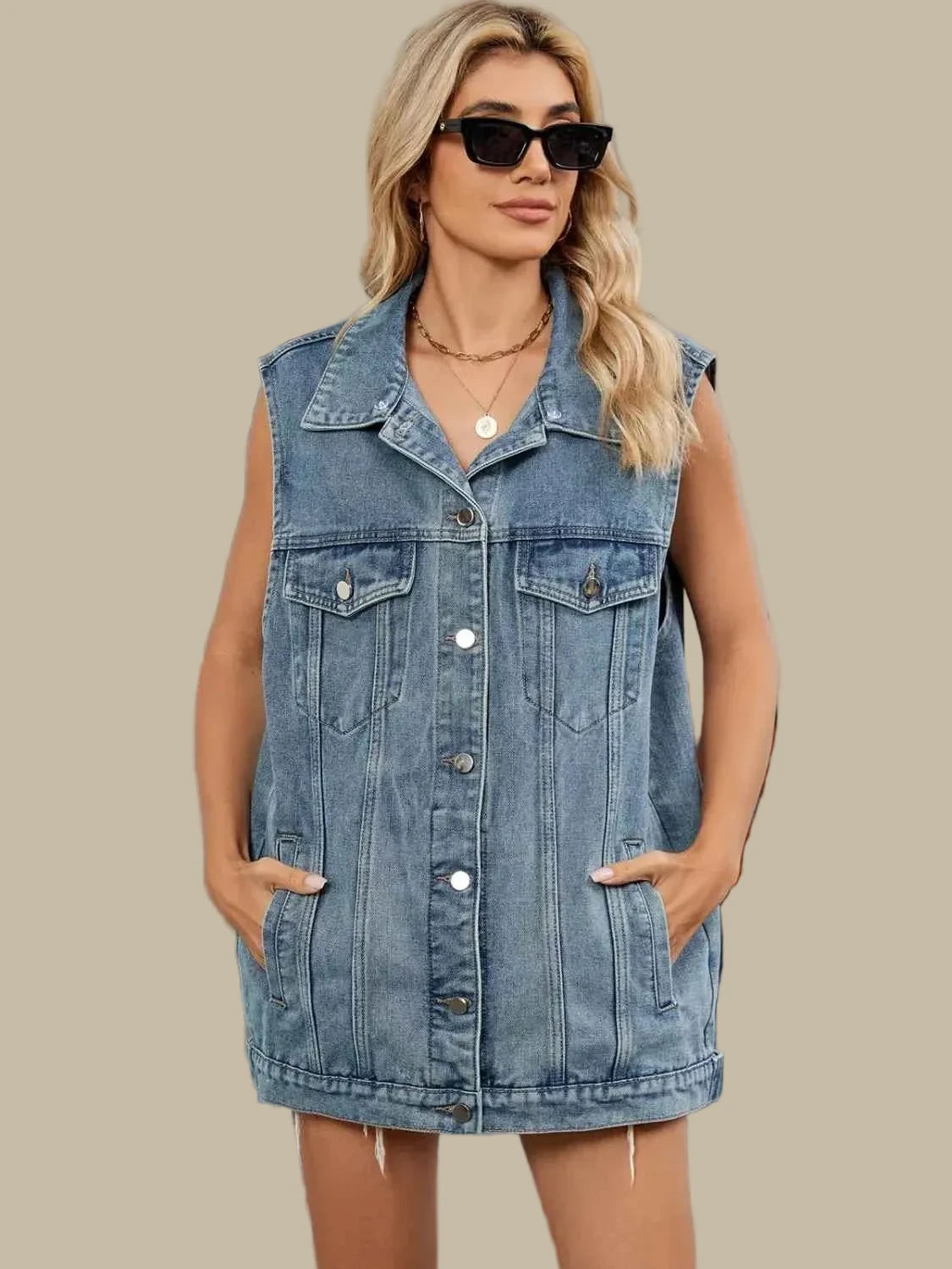 Woman wearing a denim vest and sunglasses outdoors.