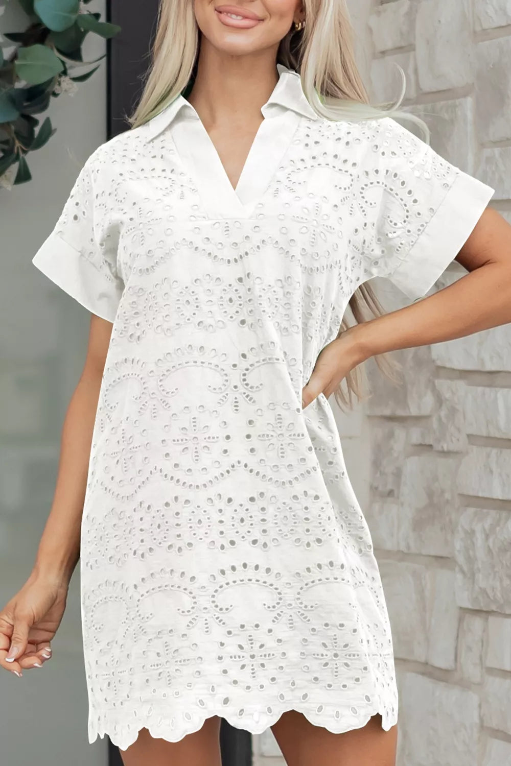 Woman wearing a white lace dress against a stone wall background