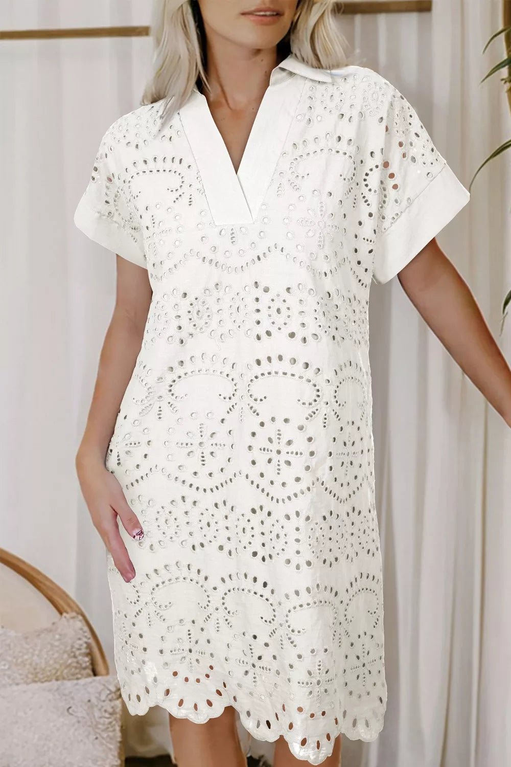 Woman wearing a white lace dress against a neutral background